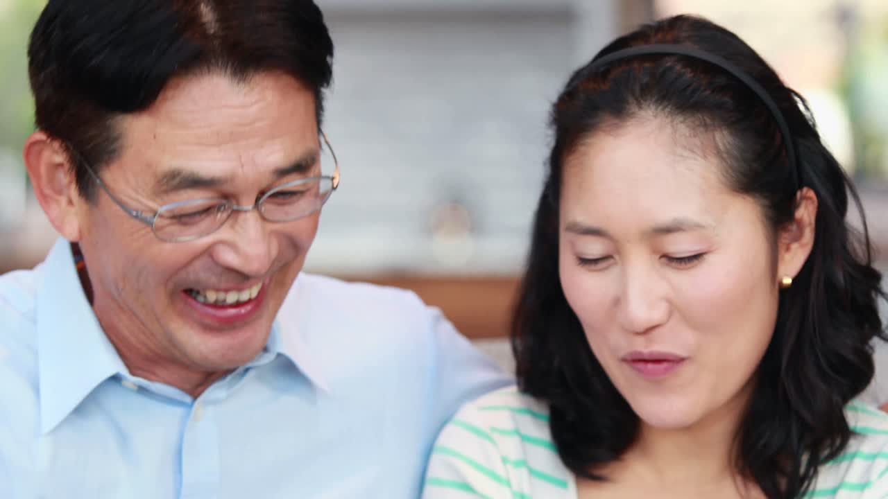 아시아 커플 이 함께 전화 를 보고 있다