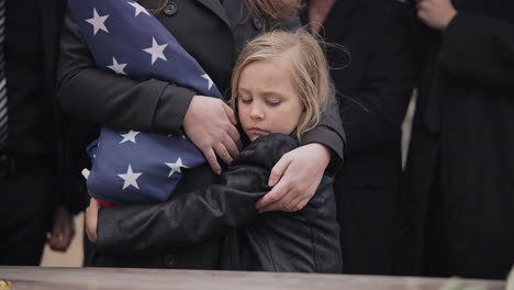 sad, hug and a child at a funeral