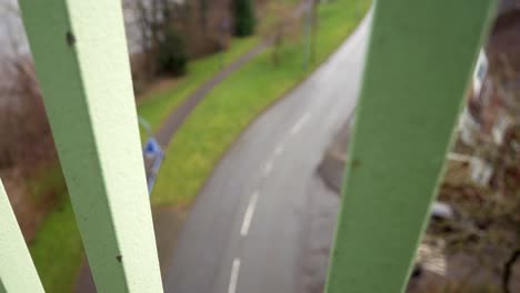 looking down between metal bridge footbridge railings to road below depression feeling slow left dolly