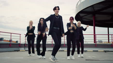 Junge-Mädchenband-Tanzt-Im-Schwarzen-Outfit-Auf-Der-Gebäudespitze