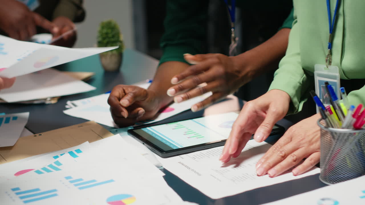 Diverse team members meeting after hours to share data reports