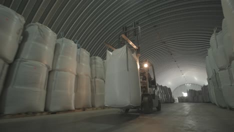 warehousing. forklift driver stacking big bag of raw material in warehouse.