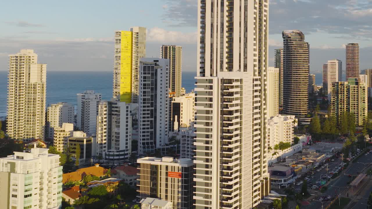 Drone footage captures Gold Coast's skyline, highlighting skyscrapers and bustling highway under warm daylight