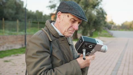 elderly man notices something wrong while filming with his old camera