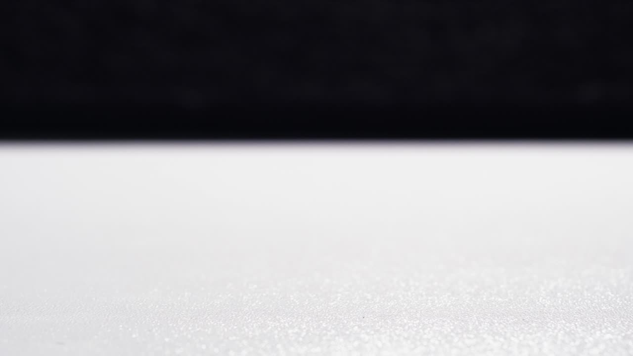 Loopbar stop-motion af møntstakke, der stiger og falder i cyklusser på en hvid overflade.