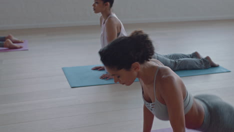 yoga class of healthy women practicing downward-facing dog pose enjoying exercising in fitness studio instructor leading group meditation teaching workout posture at sunrise