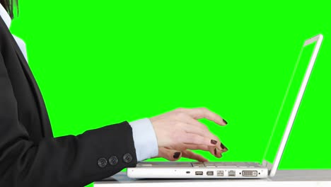 mujer de negocios escribiendo en su computadora portátil