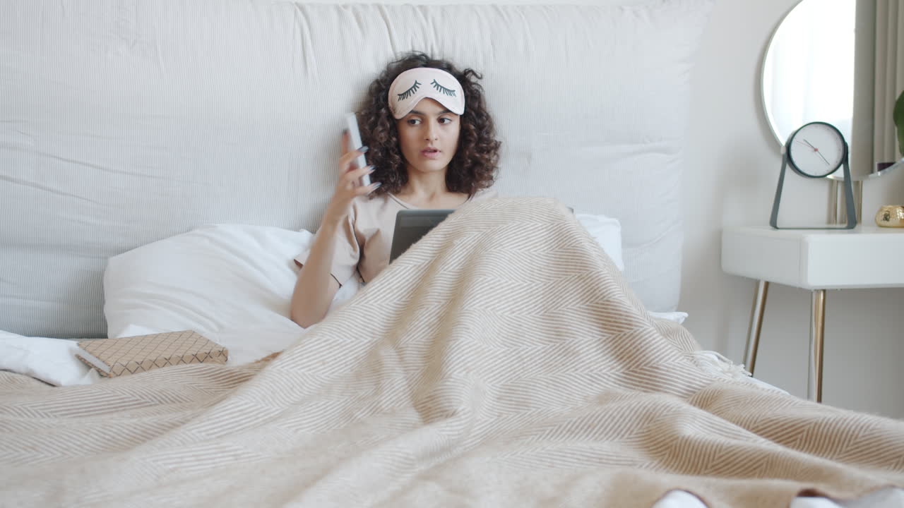 Woman Relaxing in Bed with Technology