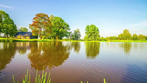 timelapse shot of a wooden cottage beside a lake throughout a cloudy day
