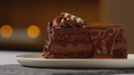 close up of melted chocolate sauce on slice of chocolate cake on plate