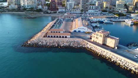 Drohnenclip-über-Dem-Wellenbrecher-Und-Backbordgebäuden-Im-Jachthafen-Der-Stadt-Calpe-In-Spanien