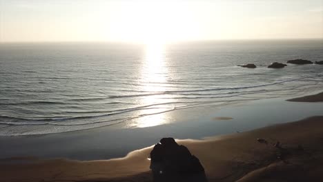 a drone view of the oregon coast, breaking waves and evening light