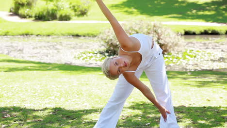 woman holds an aerobics position as she smiles at the camera