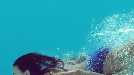 woman in blue swimsuit swimming underwater