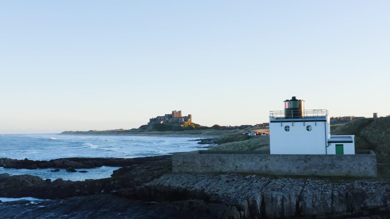 일몰 동안 bamburgh 성과 해안선의 공중 설정 샷