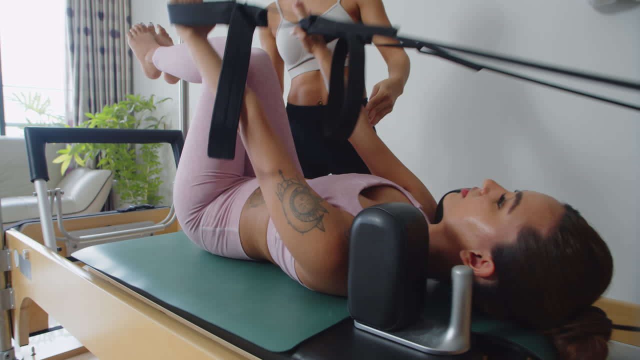 Female Athlete Using Resistance Bends while Training with Coach