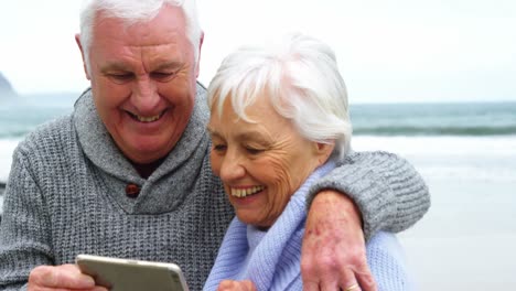 Senior-couple-checking-photos-on-mobile-phone