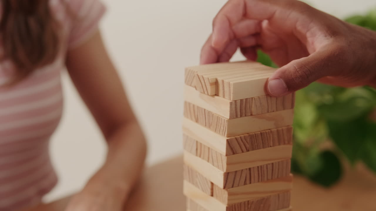 Couple Playing Block Stacking Game At Home