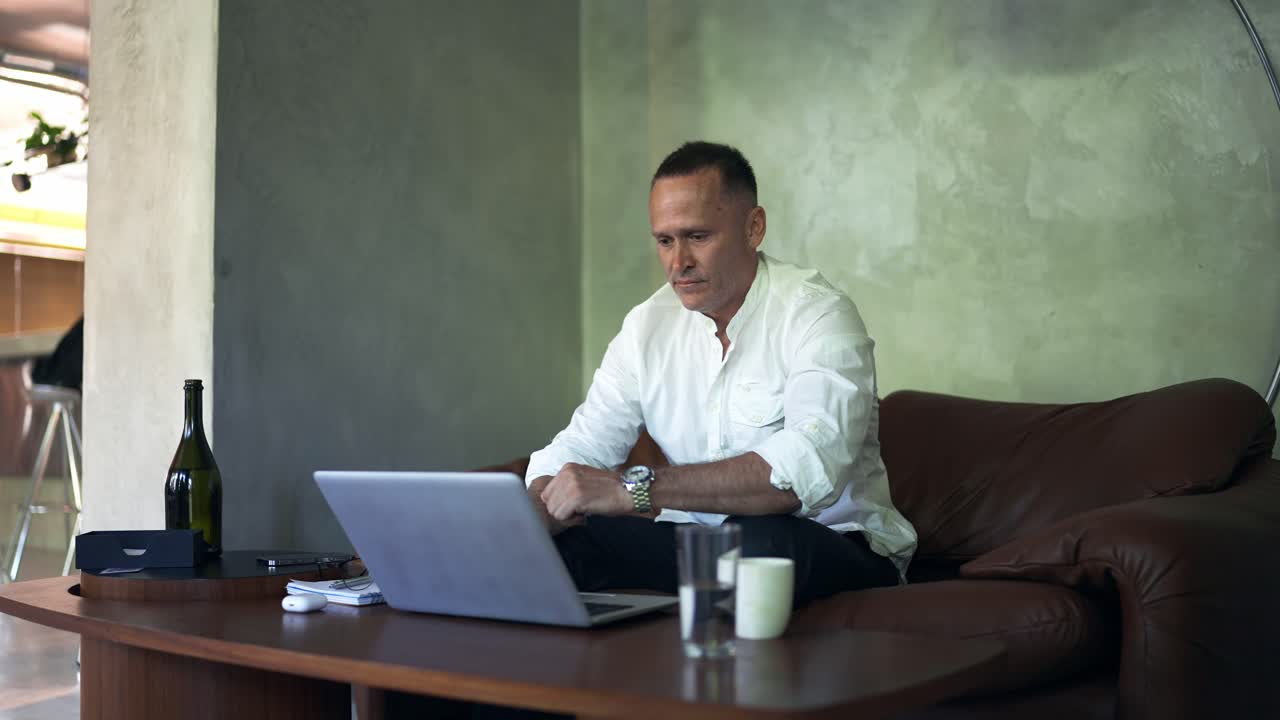 hombre de negocios trabajando en una computadora portátil en la oficina de casa. hombre profesional escribiendo en el teclado de la computadora portátil en el lugar de trabajo de la oficina. retrato de hombre de negocios positivo mirando la pantalla de la computadora portátil en el interior