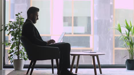 focused arabic businessman using laptop sit on office chair