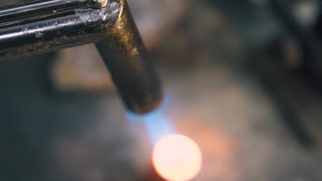 heating metal detail with gas burner flame to make jewelry