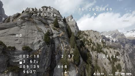 fpv aéreo volando sobre las montañas de val di mello en italia con superposiciones de seguimiento de telemetría de vuelo que muestran altitud, brújula y niveles de batería