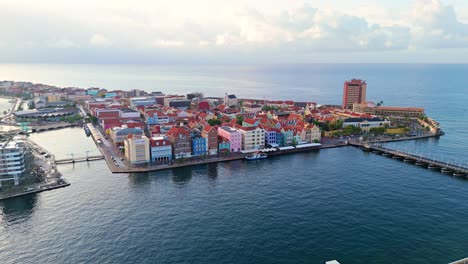 Aerial-parallax-at-sunrise-around-colorful-buildings-of-Willemstad-Curacao,-tourists-paradise