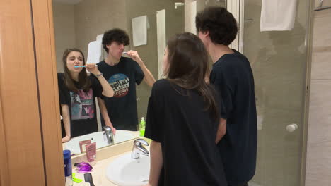teenagers brushing teeth in a hotel bathroom