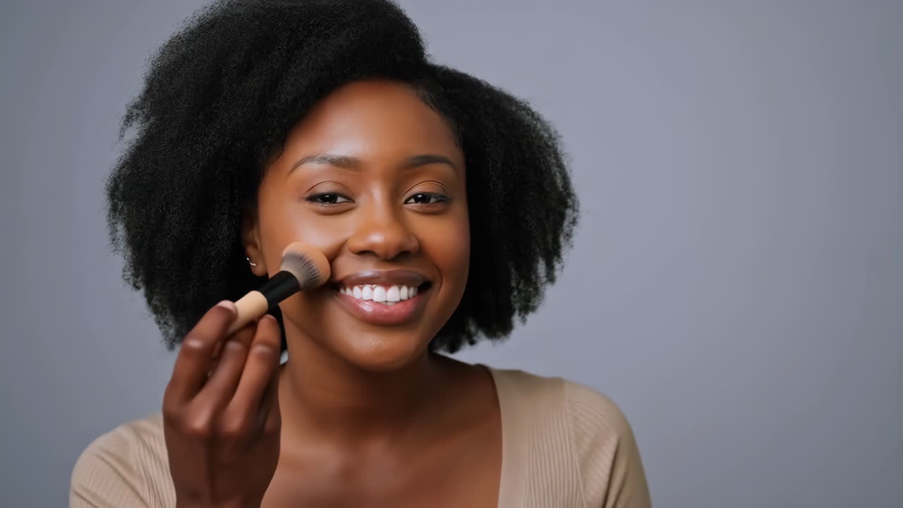 Smiling Black Woman Applying Face Makeup