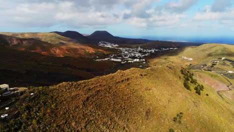 Hermosas-Casas-De-Pueblo-Blanco-En-El-Valle-De-La-Montaña-En-La-Isla-De-Lanzarote,-Vista-Aérea-De-Drones