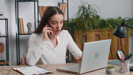 businesswoman talking on phone and working on laptop in office