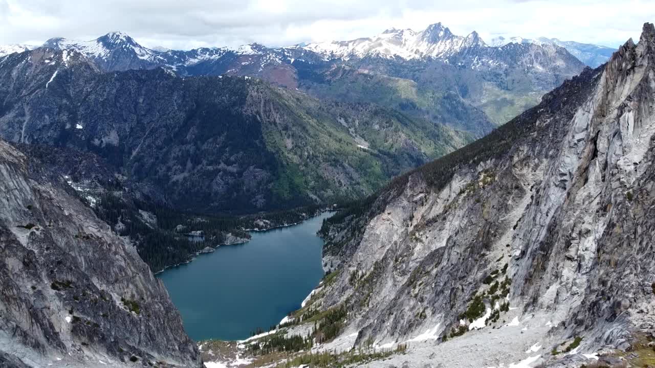 imágenes de drones de alto vuelo del lago colchuck, es agua turquesa, y muy por encima del paso aasgard cerca de los encantamientos en la cordillera de la cascada de washington: musgo, árboles y acantilados nevados