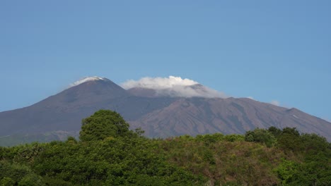 volcano mt. etna in sicily, italy wakes up and releases steam into the sky