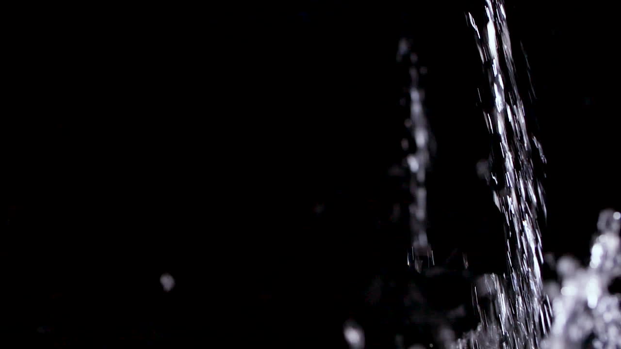 Stream of Clear Water pouring into black background in slow motion 240p