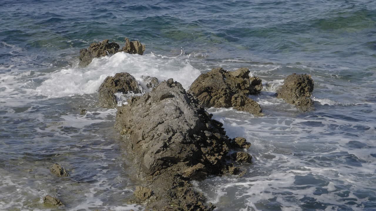 Onde che si infrangono sugli scogli al rallentatore