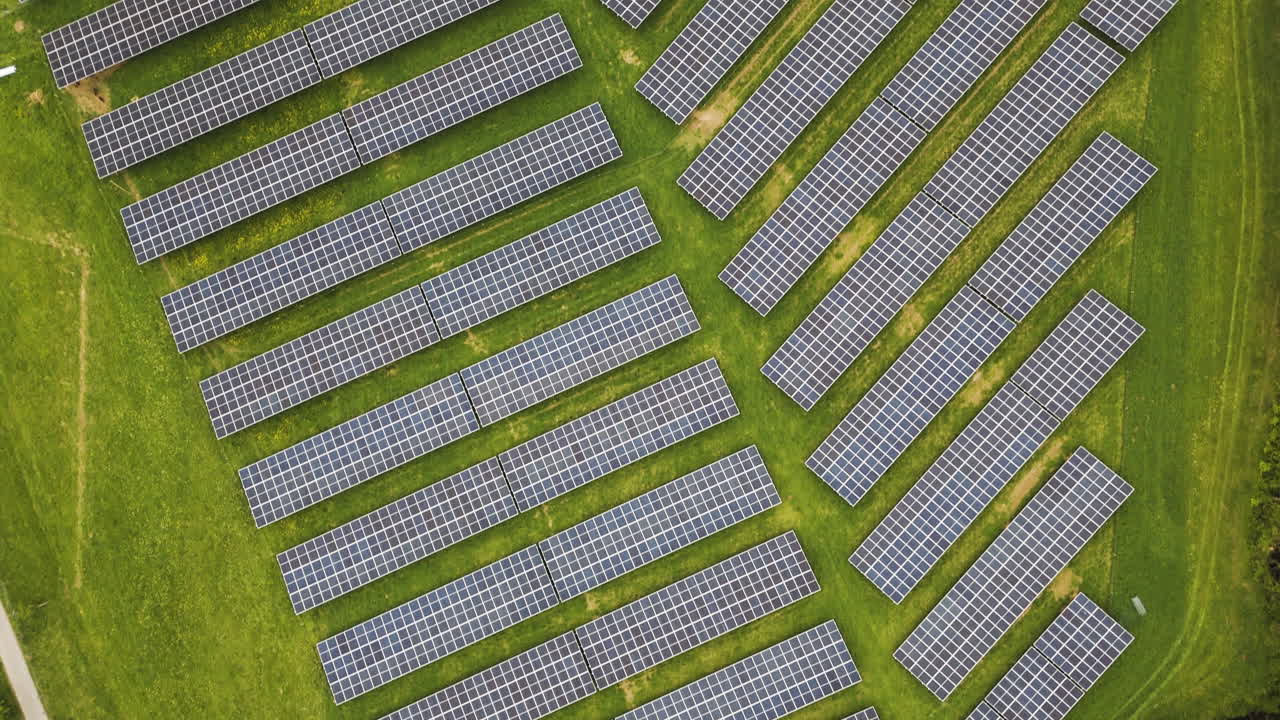 Droneflight over solar park in Austria. Slowly flying over a field of solar panels at a local farm. Agricultural use of photovoltaic panels benfits the farm animals and helps reducing CO2 emissions.