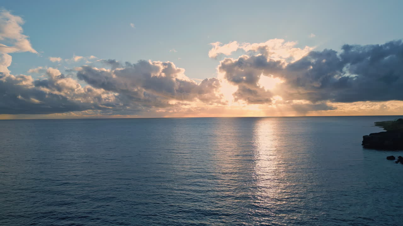 Vista drone della superficie marina all'alba. Raggi di sole che si riflettono sull'ampia distesa d'acqua del mare.