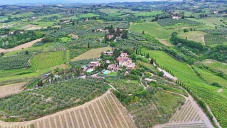 drone footage of tuscan farm with green hills with fields in italy.