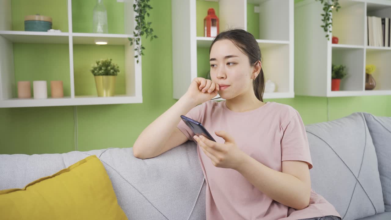 스트레스를 받은 아시아 젊은 여성이 전화로 나쁜 소식을 듣습니다.