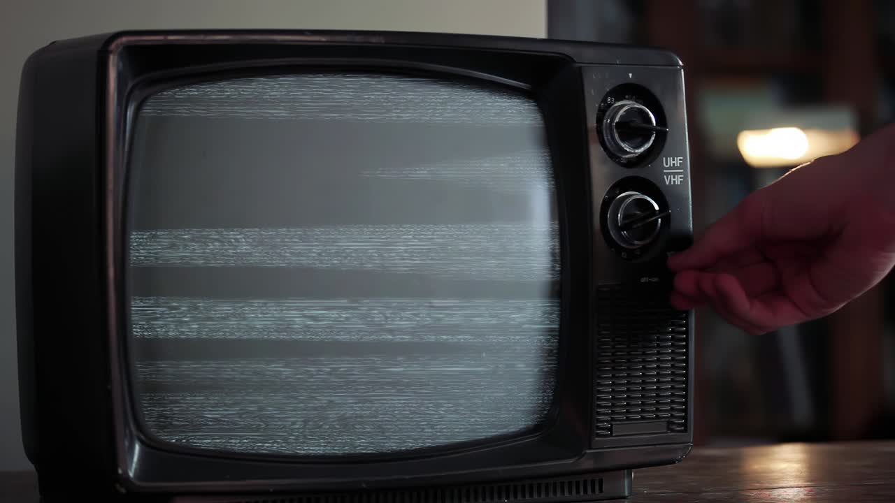 mano masculina encendiendo la televisión retro con ruido estático y pantalla verde. zoom en. resolución 4k.