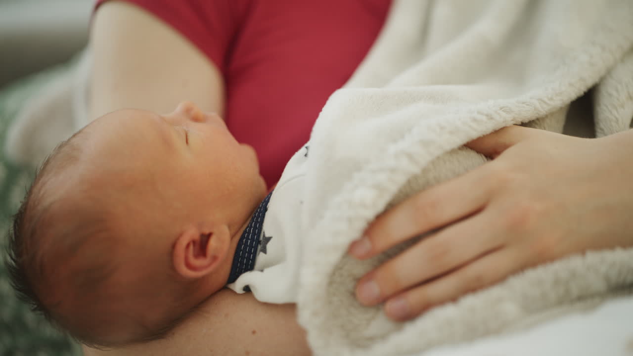 Close-up of Newborn Cuddled to Mother