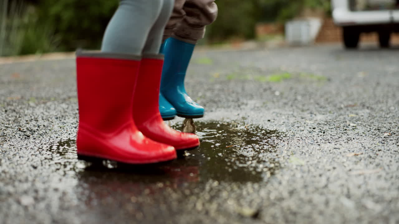 Feet of children, road and jumping in water puddle