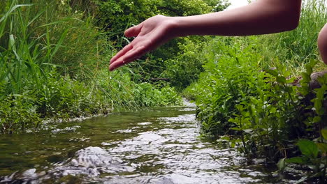 woman playing with hand in the river.
