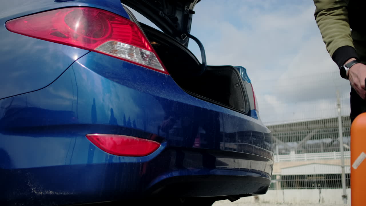 자동차 트크 에 가방 을 실고 있는 사람