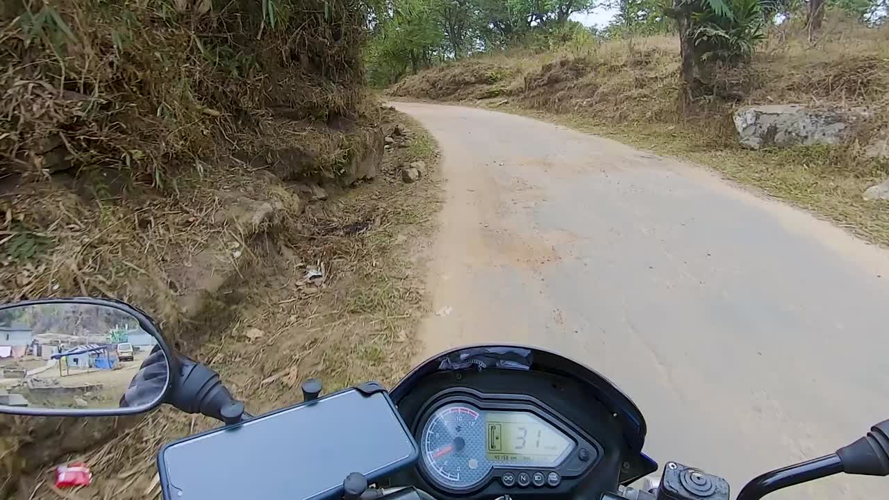 motociclista montando una bicicleta en un asfalto remoto durante el día desde un ángulo plano