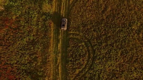 aerial view of a car on a country road through a field