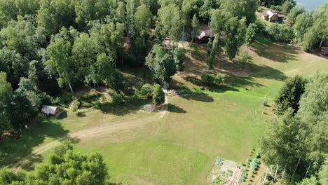 Coastal-old-homesteads-near-lake-water-in-Lithuania,-aerial-drone-view