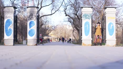 woman in a park entrance with graffiti