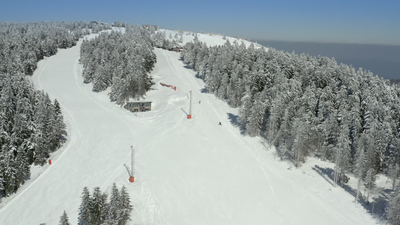 Aerial view of a snowy ski resort with slopes and trees