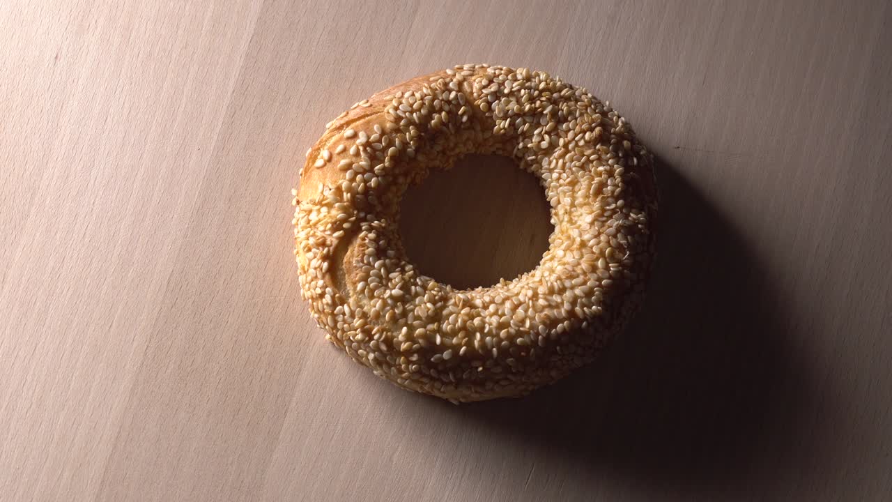 bagels frescos con semillas de sésamo en rotación. en la tabla de cortar de madera. primer plano extremo.